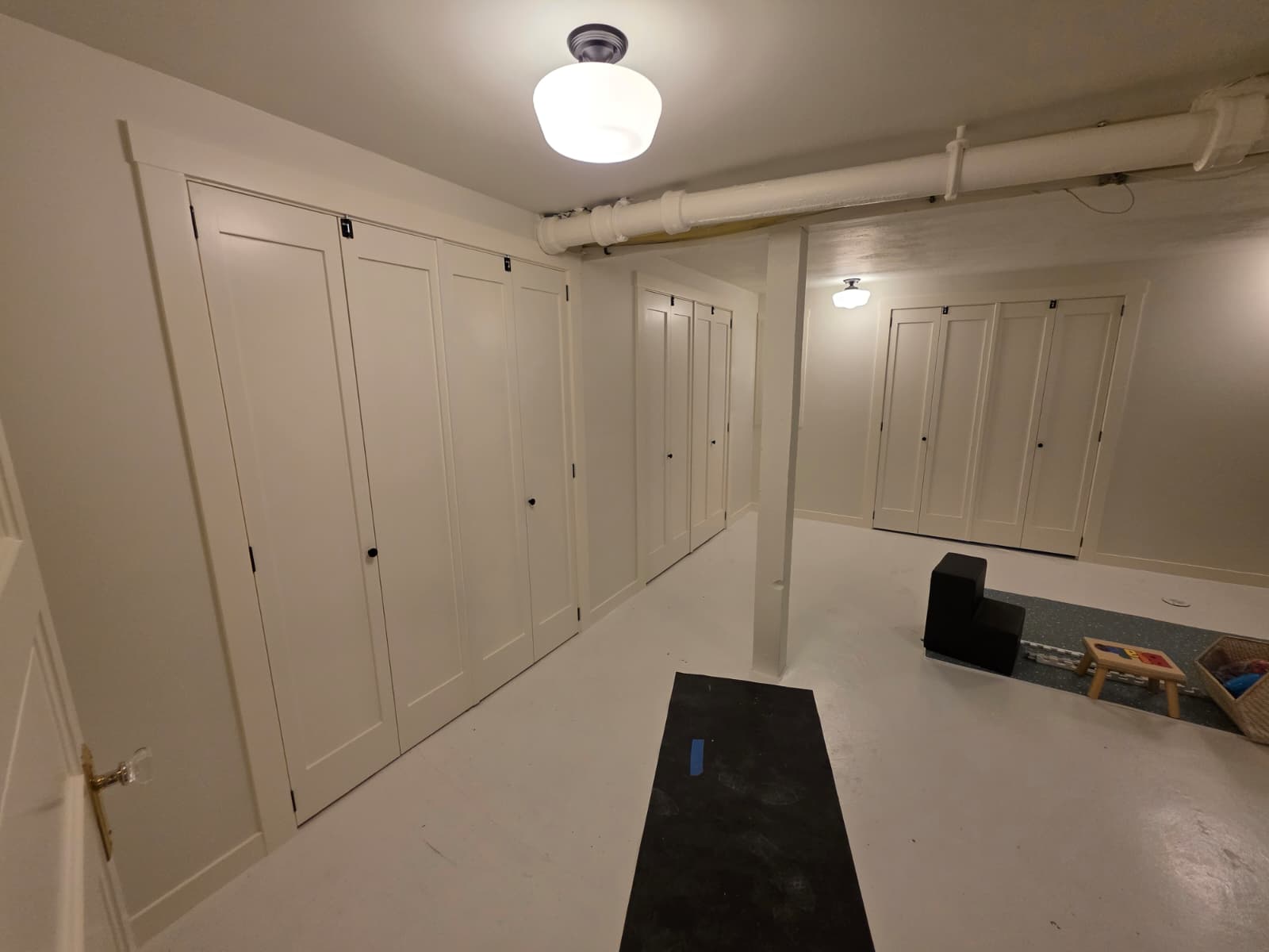 Finished basement interior with freshly painted white walls, doors, and ceiling
